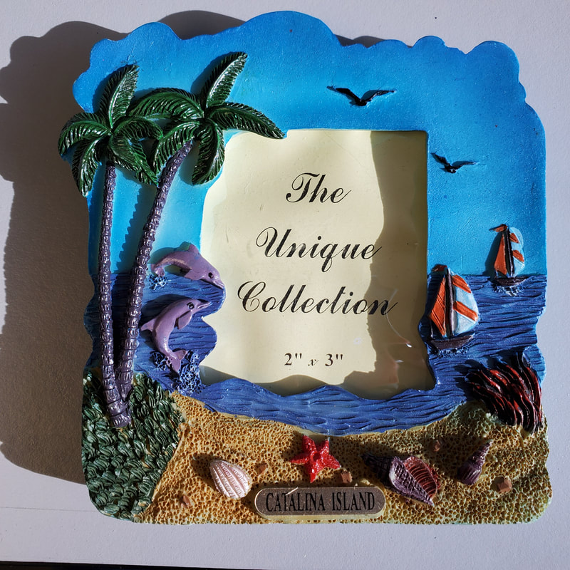 49434-01 Catalina Island Souvenir poly resin picture frame, holds 2" x 3" picture.  Beach scene, shells, dolphins, palms, sand, surf and sailboats. 