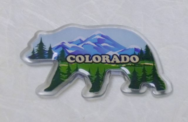 Colorado Souvenir Plastic bear-shaped magnet with mountains design. 