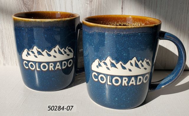50284-07 Colorado souvenir mug with blue exterior and brown interior, and debossed white mountains design