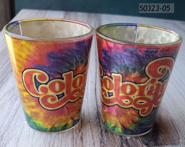 50323-05 Colorado Souvenir Shotglass with Holographic foil imprint in vivid rainbow tie dye with the word Colorado across the center. 