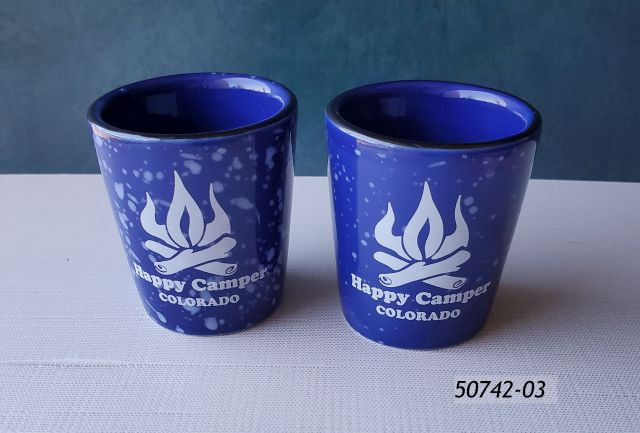 50742-03 Colorado Souvenir Ceramic Shot with blue speckle coating and a white campfire design that reads Happy Camper Colorado. 